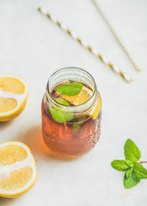Summer cold Iced tea with lemon slices and fresh herbs
