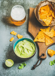 Mexican corn chips fresh guacamole sauce and glass of beer