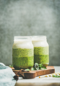 Ombre layered green smoothies with fresh mint in glass jars