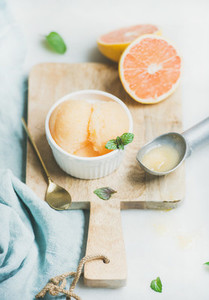 Pink grapefruit sorbet with fresh mint leaves in bowl