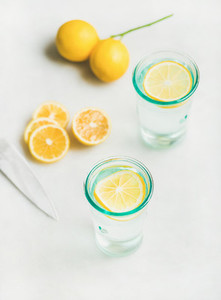 Detox lemon water in glasses served with fresh lemon fruits