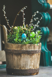 Green plants colored eggs willow tree branches in wooden tub
