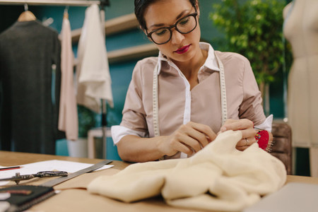 Seamstress hand stitching a designer dress