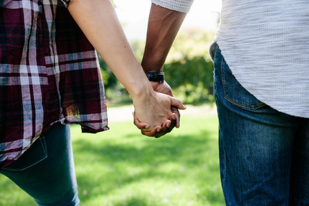 Couple holding hands and walking outdoors