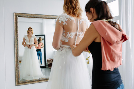Bride trying on wedding dress in a shop