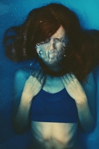 Young woman under blue water