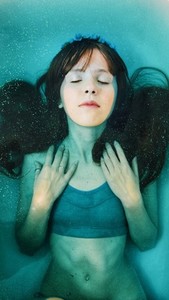Young woman under blue water