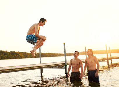 Teenage boy jumping into a lake