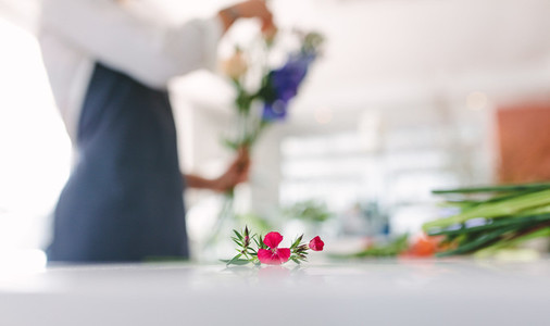 Flower on counter with florist working in background