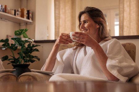 Woman having coffee and relaxing at spa salon