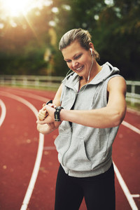 Portrait of blonde athlete looking at her watch