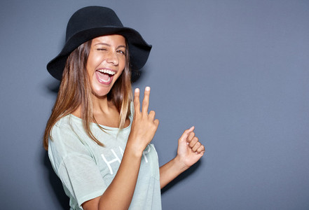 Excited young woman making a V sign gesture