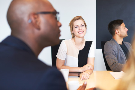 White female executive smiling at camera during meeting