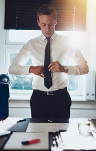 CEO executive business type white male tying his tie