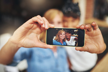 Two women friends taking a selfie on a mobile