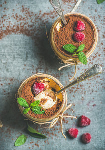 Homemade Italian dessert Tiramisu in glasses with berries and mint
