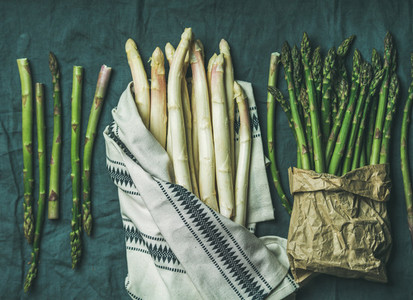 Fresh green and white asparagus in towel  grey background