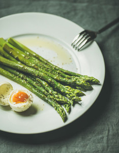 Cooked asparagus with soft boiled egg and herbs  selective focus