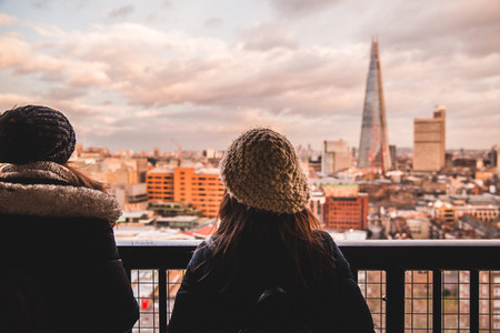 Two young tourist female friends looking at modern London skylin