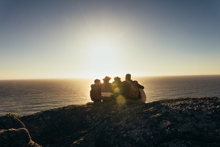 Friends admiring the sunset from mountain top