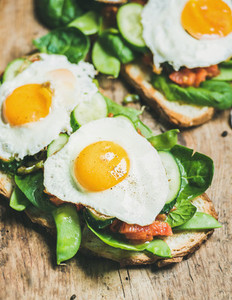 Healthy breakfast sandwiches on wooden board background