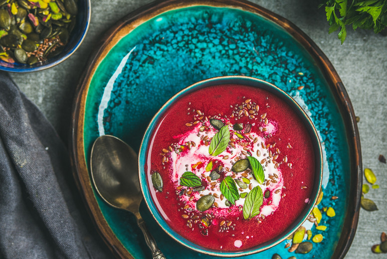 Spring beetroot soup with mint leaves and seeds, top view