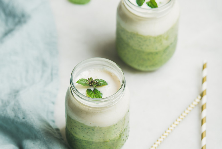 Ombre layered green smoothies with mint in jars, square crop