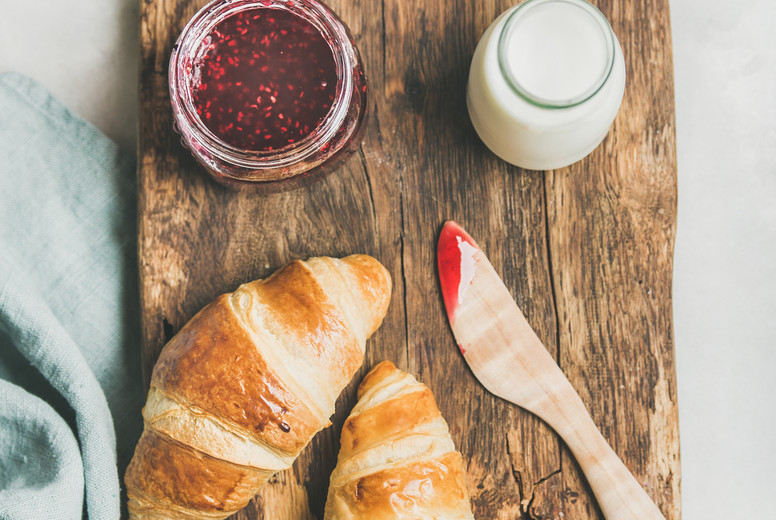 Freshly baked croissants with raspberry jam and milk in bottle