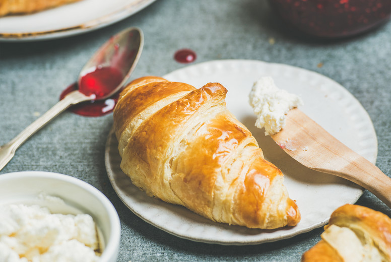 Croissants with raspberry jam, ricotta cheese and milk, square crop