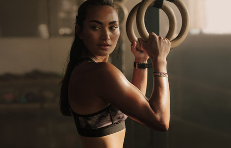 Woman exercising with gymnastic rings in gym