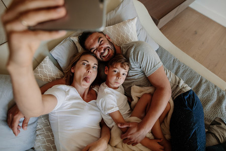 Crazy family on bed taking selfie