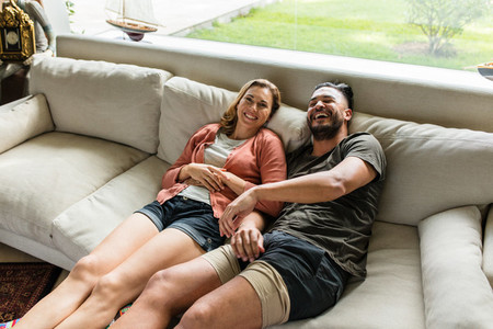 Smiling young couple relaxing on sofa