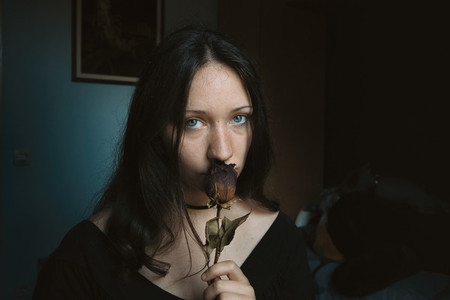 girl looking at camera with a dry rose