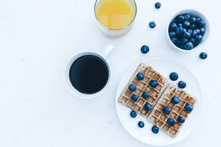 Waffles and blueberries breakfast with coffee and orange juice