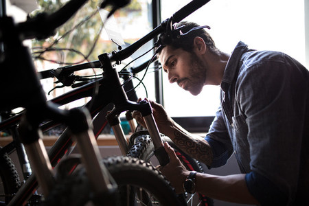 Worker inspecting a bicycle in workshop