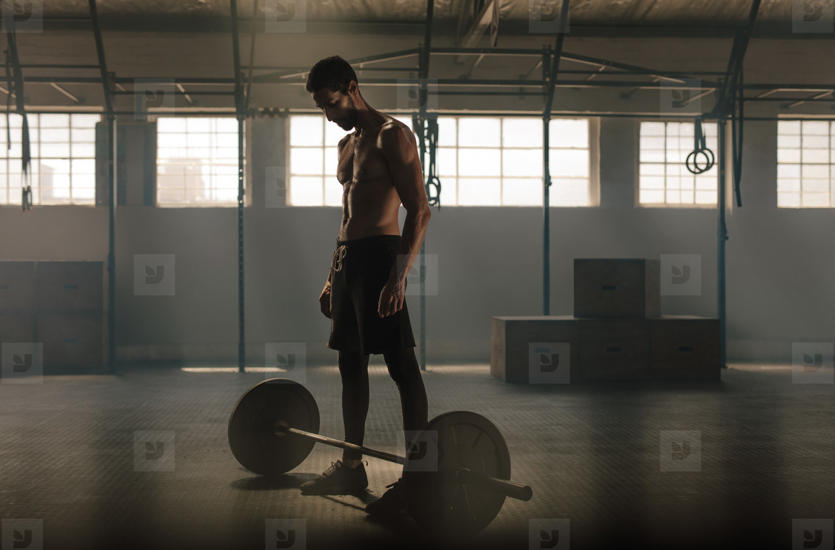 Man exercising with barbell at gym