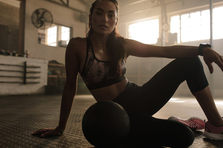 Fit young woman in gym with medicine ball