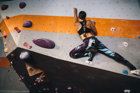 Woman climbing indoor boulder wall