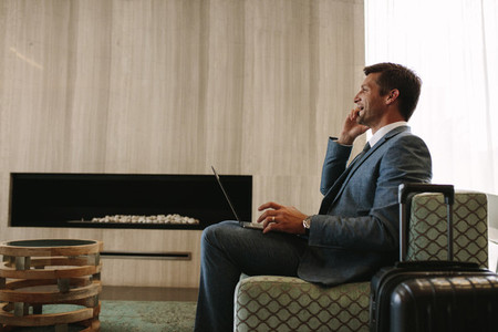 Business traveler waiting for his flight in airport lounge