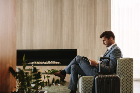 Businessman reading a magazine while waiting for his flight