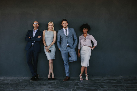 Diverse business team standing together against a wall