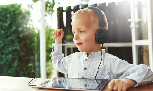 Happy little boy listening to music