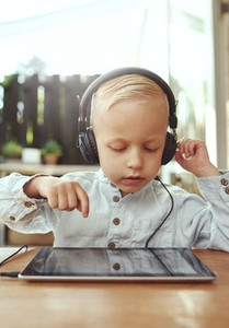 Adorable serious little boy choosing a soundtrack