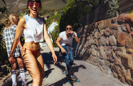 Cool young woman skateboarding with her friends
