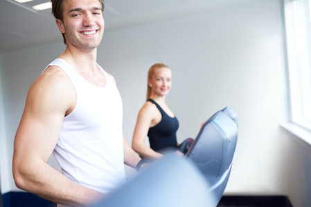 Athletic Young Man on Treadmill Smiling at Camera