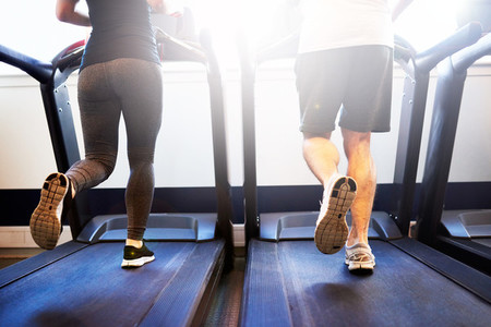 Athletic Couple Running on Treadmill Machine