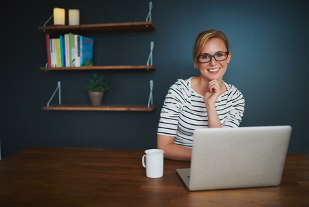 woman with laptop smiling at camera