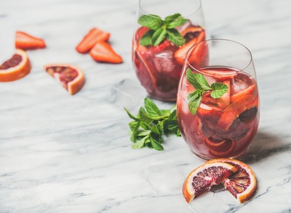 Fruit refreshing Sangria cocktails with ice cubes and fresh mint