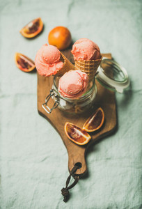 Refreshing summer blood orange ice cream on rustic wooden board