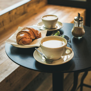 Coffee latte cappuccino and croissant on table  square crop